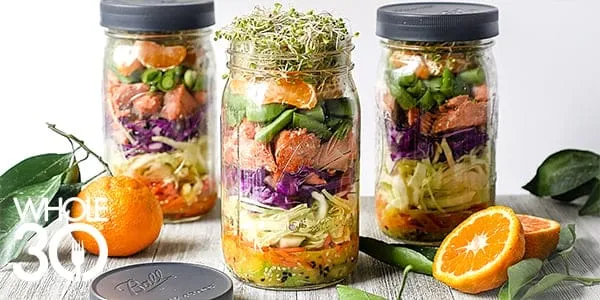 Three jars containing citrus-ginger salmon salad.