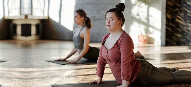 A young woman with Down’s Syndrome practices cobra pose