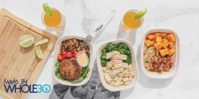 Three Made by Whole30 meals on a white marble countertop