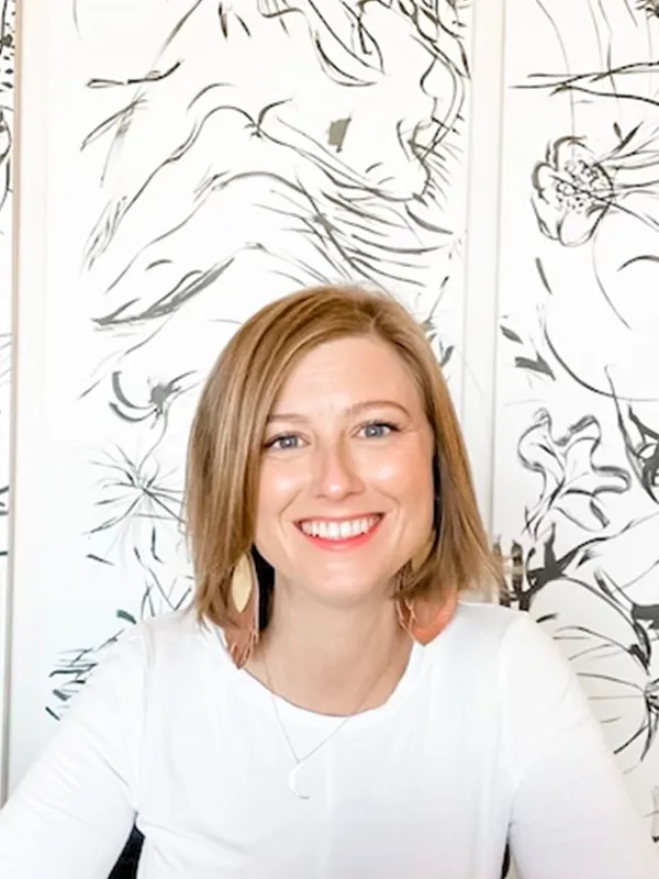 Whole30 Recipes Senior Manager, Liz Parrent sitting down in a white shirt smiling at the camera.