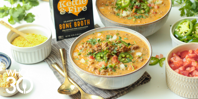 Two bowls of Whole30 Nacho Soup topped with diced tomatoes and sliced jalapeños