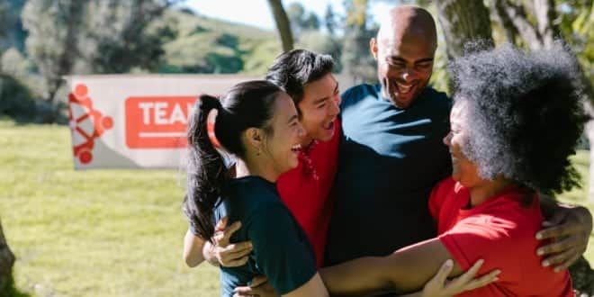 A group of people smile and hug each other