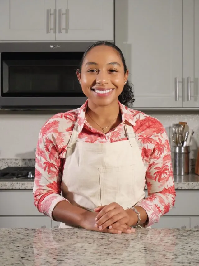 Kai Kani is a pink shirt and white apron, smiling at the camera.
