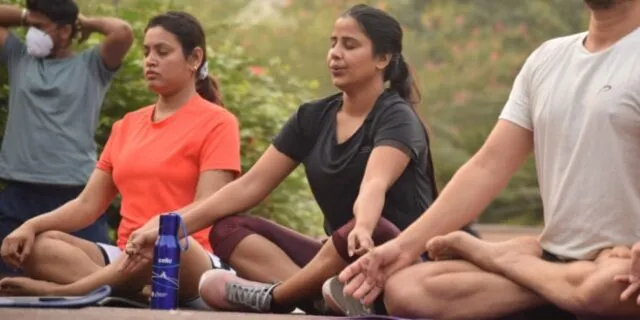 Two women and two men sit in meditation with their eyes closed