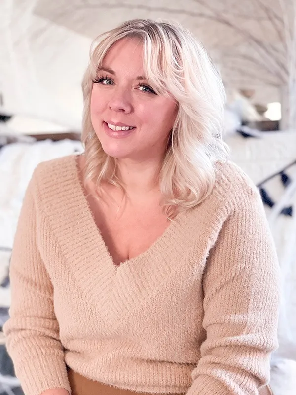 Stephanie Kelly wearing a cream colored sweater smiling at the camera.