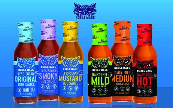 Six bottles of Noble Made sauces on a blue background.
