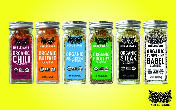 Six Noble Made seasoning bottles on a yellow background