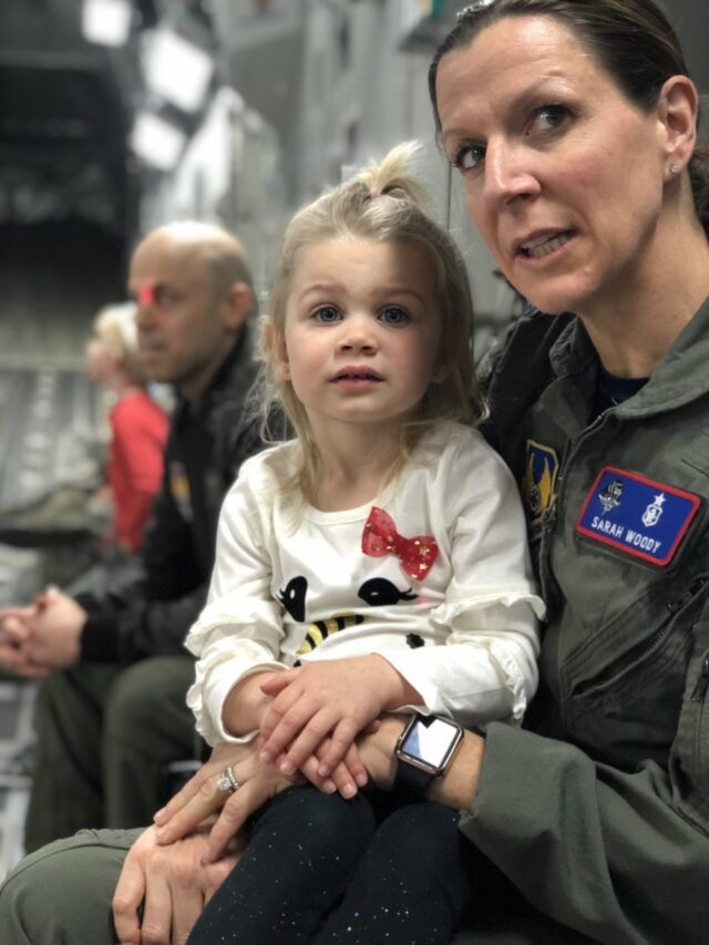 Sarah Woody in military uniform with a young child on her lap