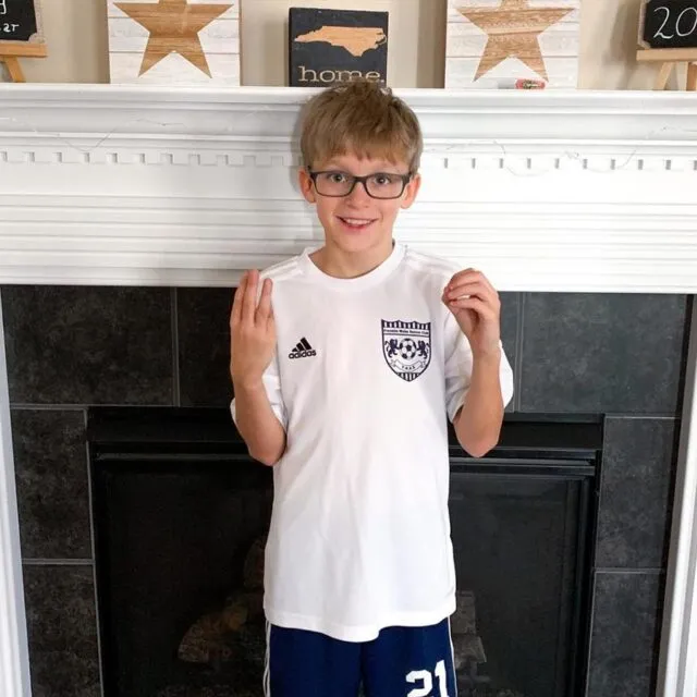 profile-AndyStacy|Any in a soccer uniform smiling in front of a fireplace