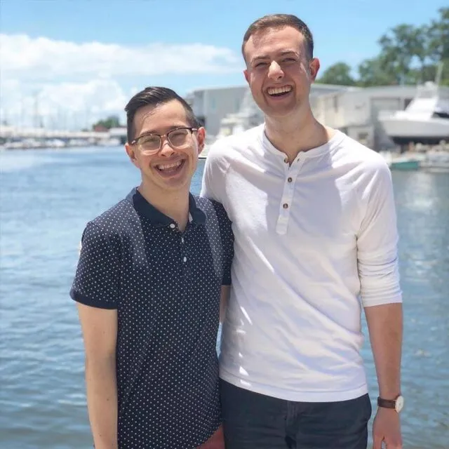 profile-StephenD|Stephen and friend smiling at camera in front of a body of water