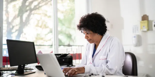 A female dietitian sitting in her office, working on her laptop.