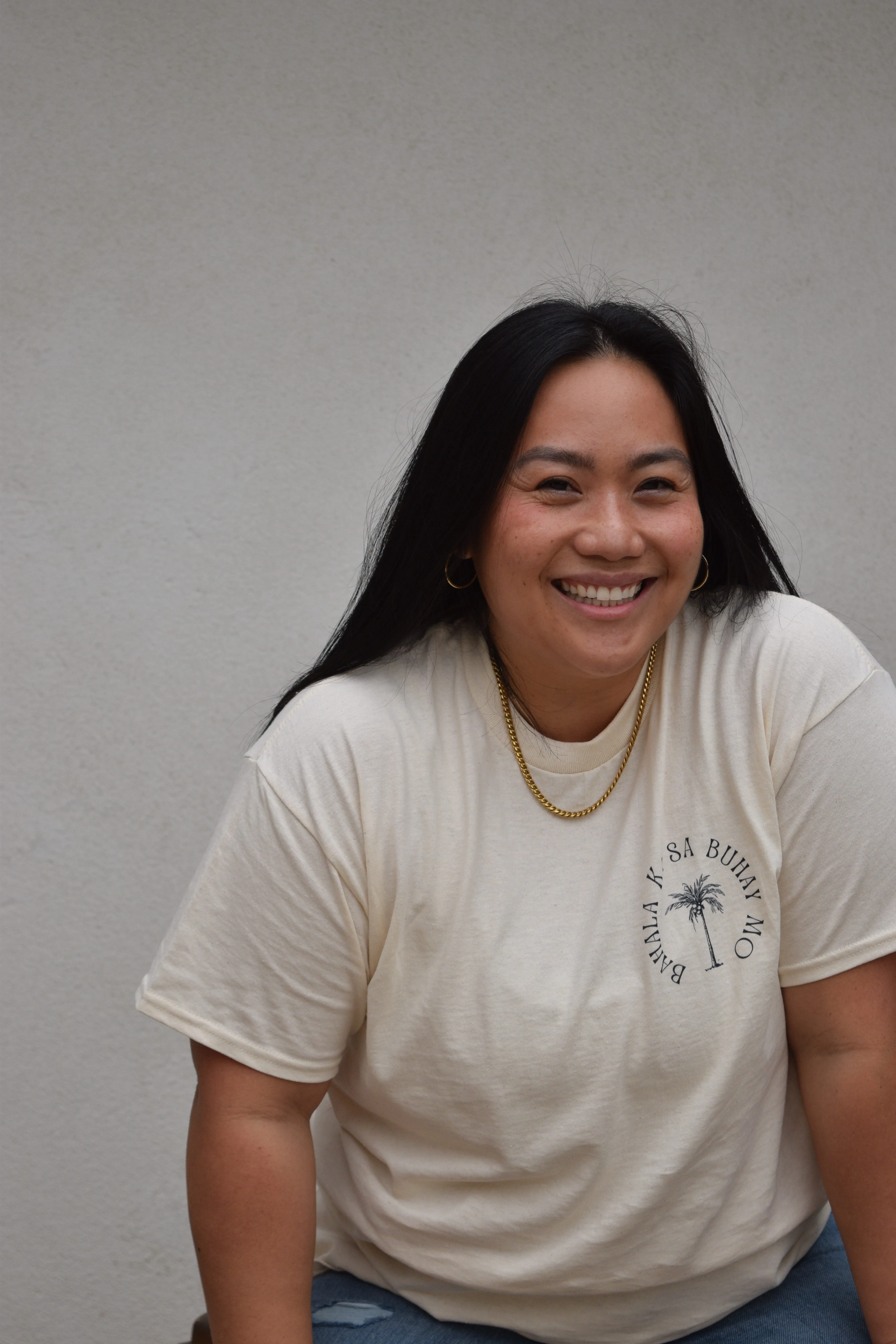 Clara Nosek in a beige t-shirt smiling at the camera.