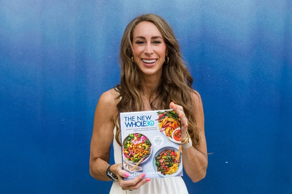 Melisa Urban holding The New Whole30 book. 